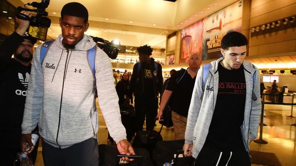 UCLA basketball players Cody Riley, left, LiAngelo Ball, right, and Jalen Hill, background center, are surrounded by the media as they leave the Los Angeles International Airport on Tuesday, Nov. 14, 2017, in Los Angeles. The three UCLA basketball players detained in China on suspicion of shoplifting returned home, where they may be disciplined by the school as a result of the international scandal. (AP Photo/Jae C. Hong)