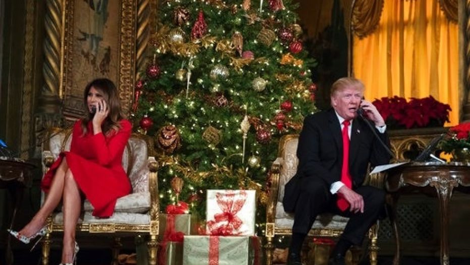 President Donald Trump and first lady Melania Trump speak on the phone with children at the president's Mar-a-Lago estate in Palm Beach, Fla., Sunday, Dec. 24, 2017.