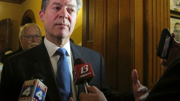 In this Jan. 9, 2018 photo, Kansas Gov. Sam Brownback speaks to reporters following his State of the State address, at the Statehouse in Topeka, Kan. Brownback is drawing criticism from fellow Republicans in the Legislature over his budget proposals. (AP Photo/John Hanna)