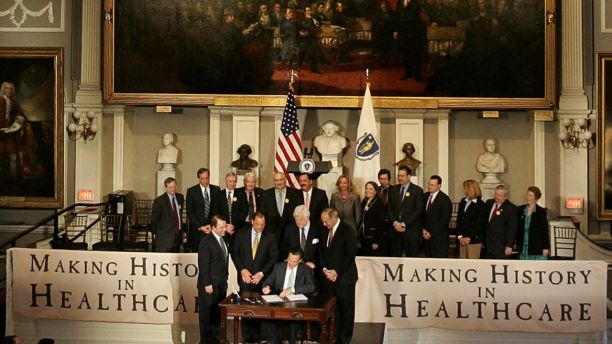 Massachusetts Governor Mitt Romney (C) signs a healthcare reform bill for the Commonwealth of Massachusetts at Faneuil Hall in Boston April 12, 2006. The bill attempts to provide health insurance for all Massachusetts residents.   REUTERS/Brian Snyder - GM1DSJHSIPAA