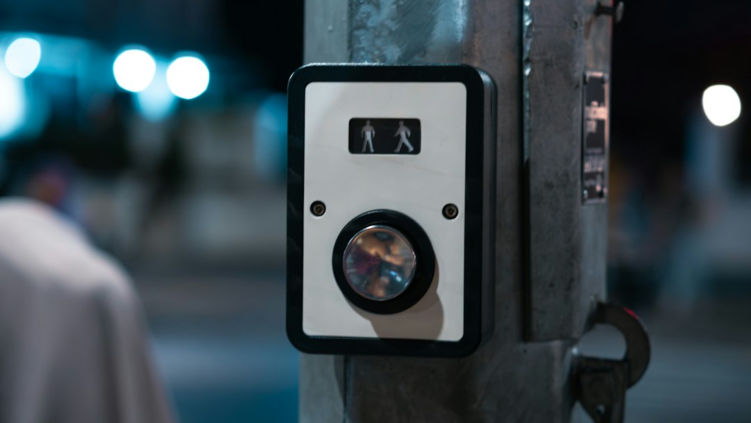 A close-up shot of a real estate lockbox attached to the doorknob of a residential brownstone's front door, representing the rise of short-term rentals in neighborhoods.
