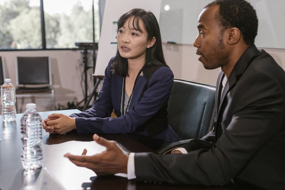 A professional listens with empathy to another person in a calm and bright office, highlighting the human-centered care that is possible when administrative burdens are reduced by AI.
